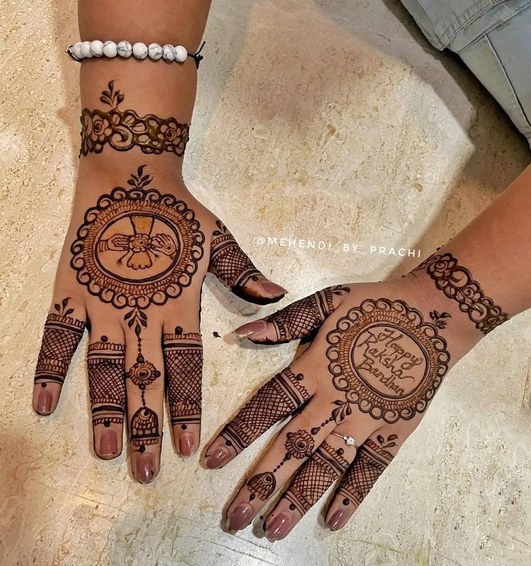 A person showing henna on their hands with a dark background