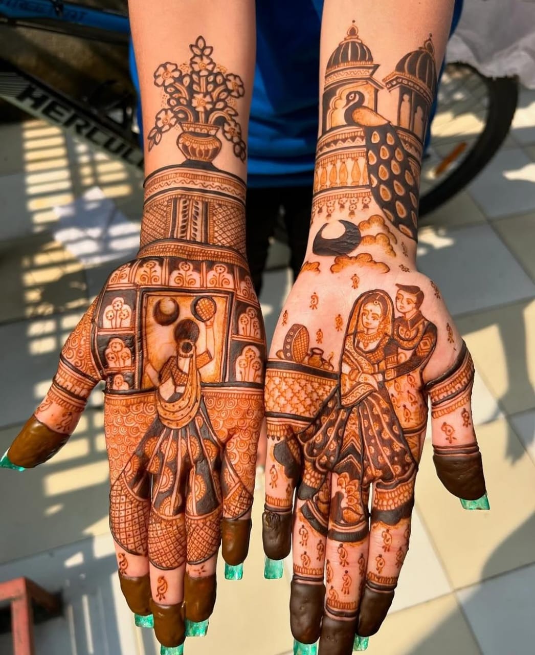 A person showing henna on their hands with a green background