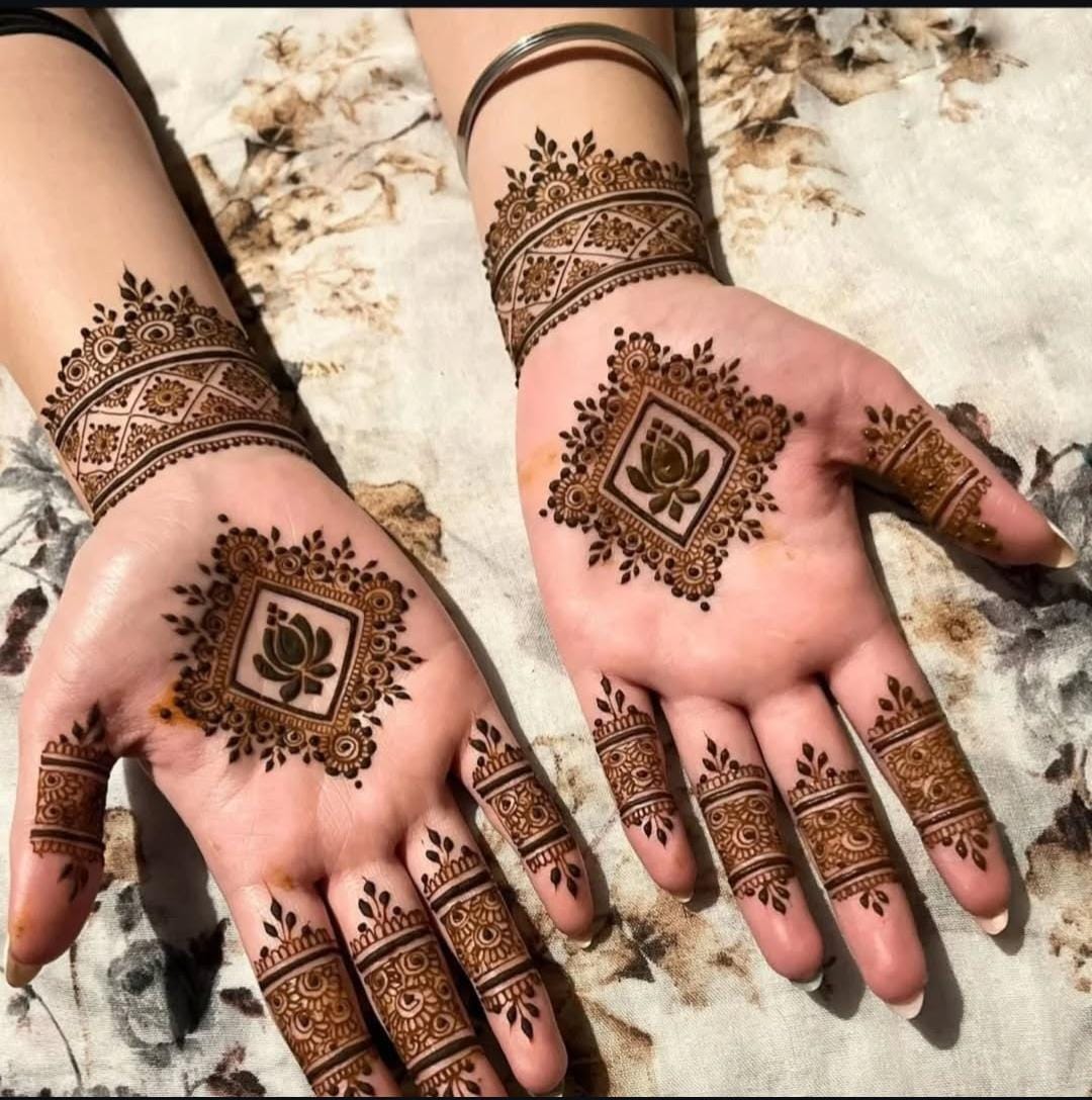 A person showing henna on their hands with a red background