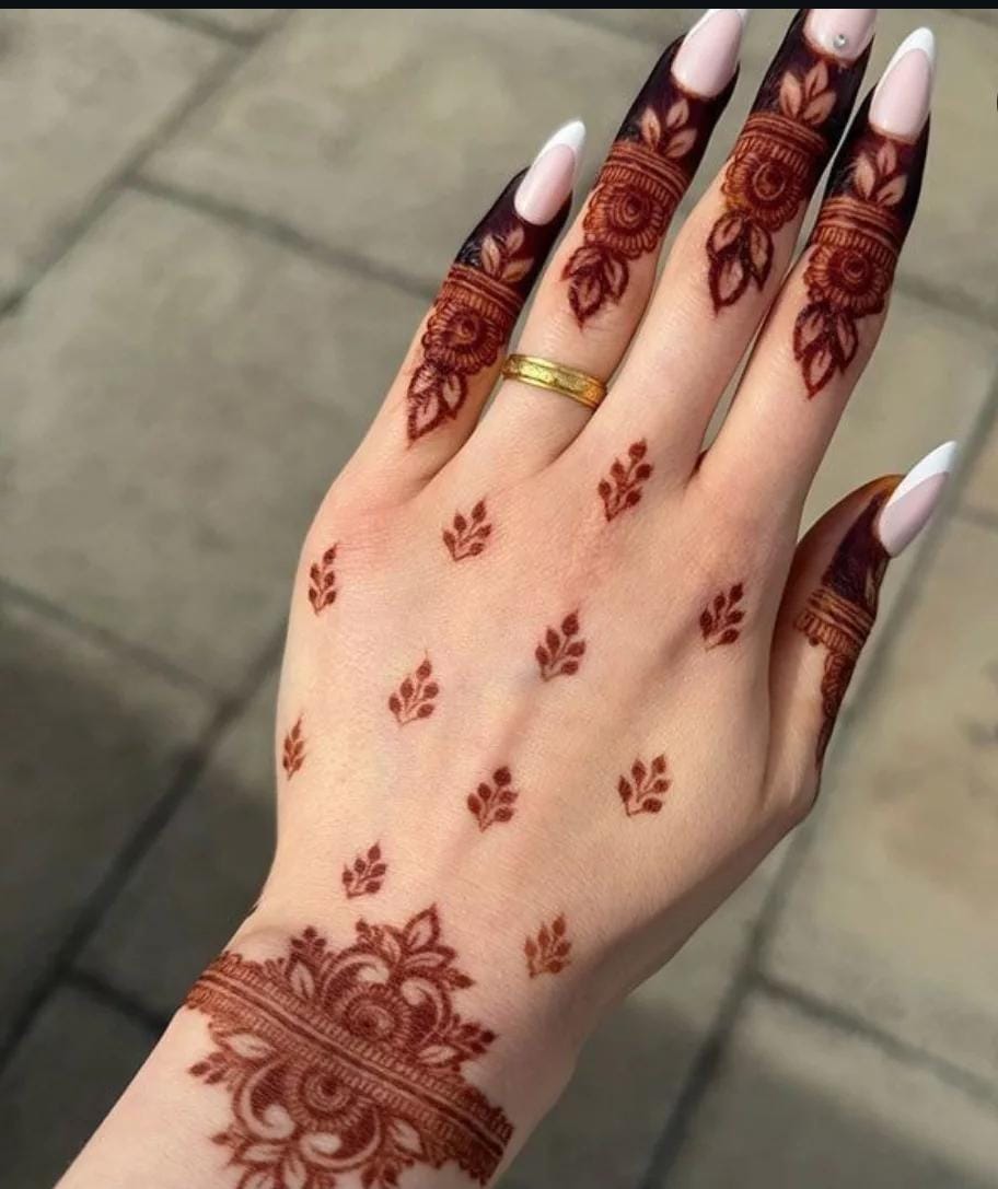 A person showing henna on their hands with a pink background