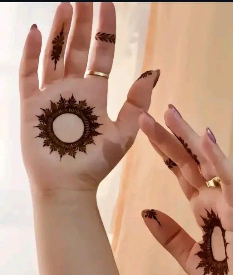 A person showing henna on their hands with a colorful background